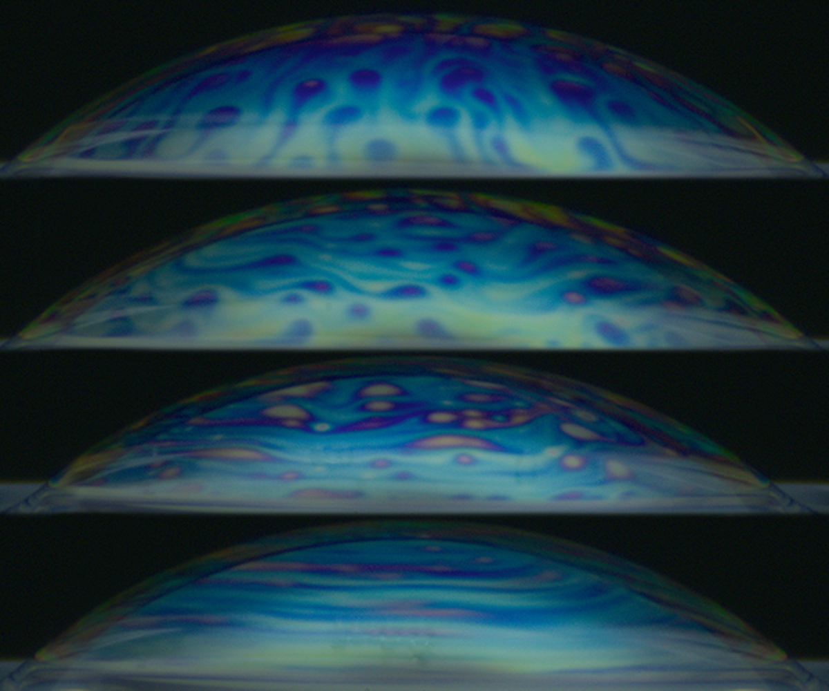 Surface bubble lifetime in the presence of a turbulent air flow, and the effect of surface layer renewal